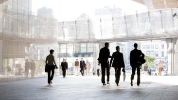Business people walk to and from a modern city building