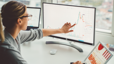 A woman consults financial data on a computer screen