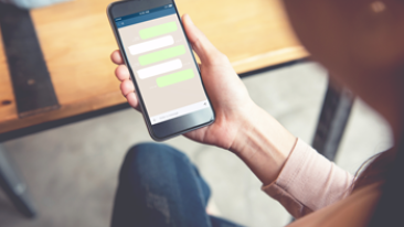 Man holding a phone that shows a conversation