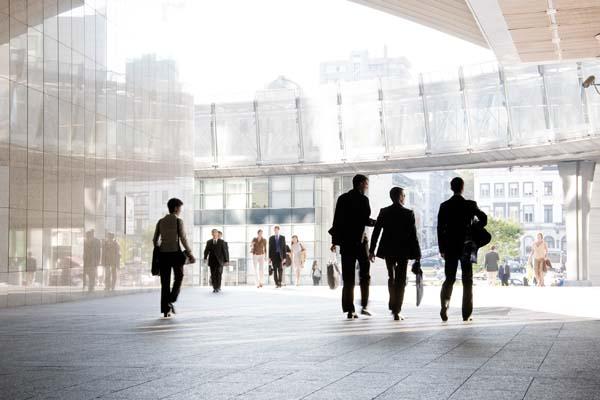 Business people walk to and from a modern city building