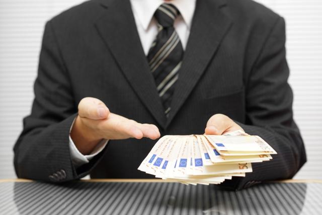 Fake credit: a businessman offers a bunch of 50-euro banknotes Fake credit: a businessman offers a bunch of 50-euro banknotes